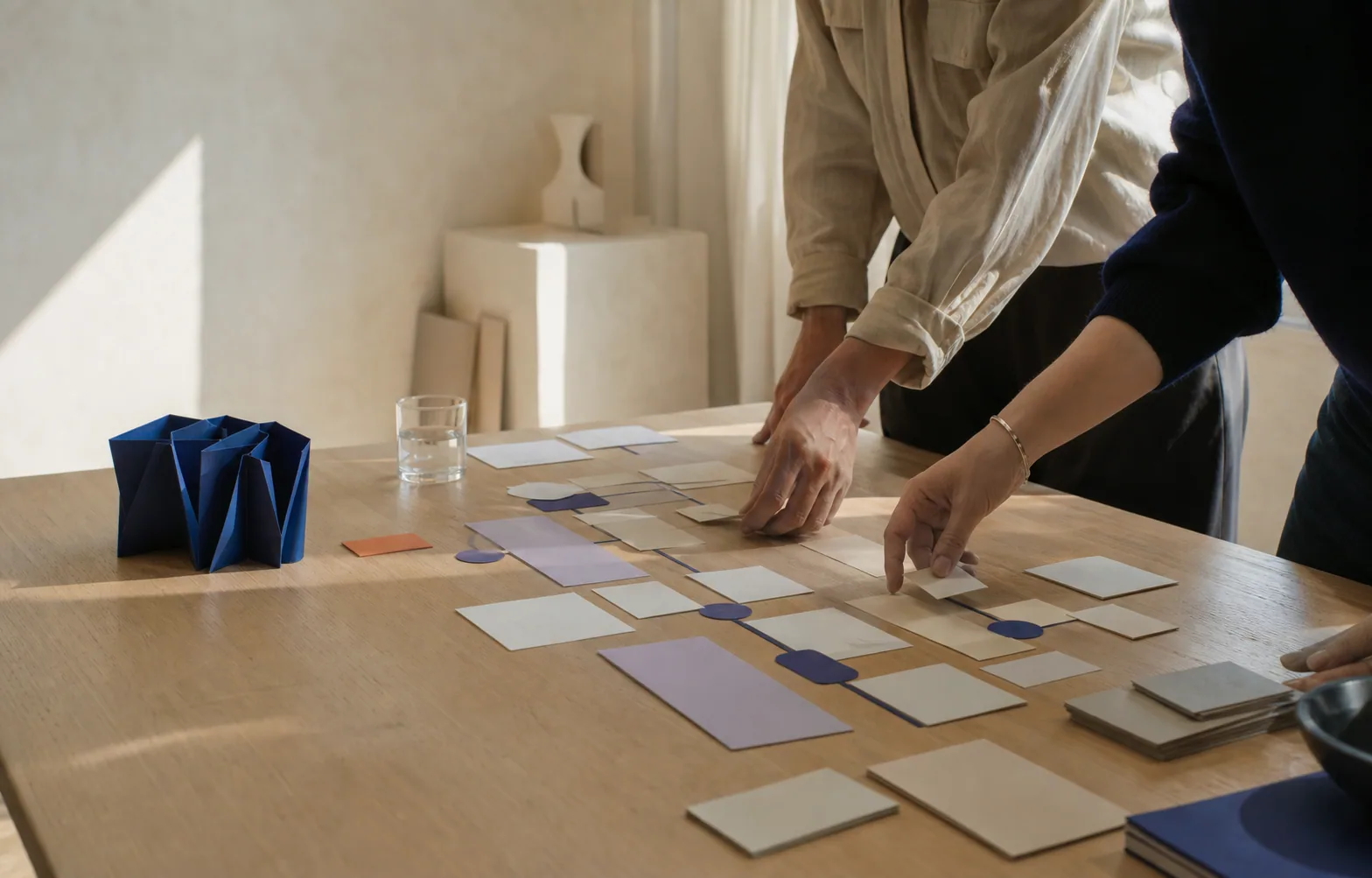 Hands mapping a practical workflow in a warm studio